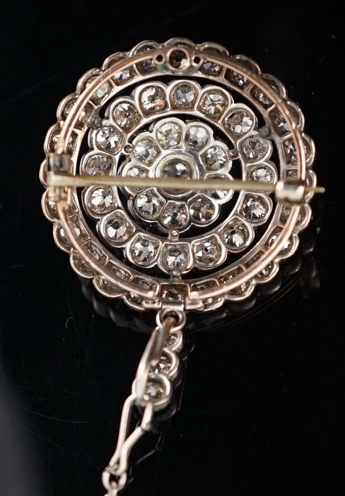 An early 20th century gold, platinum and millegrain set diamond cluster target brooch